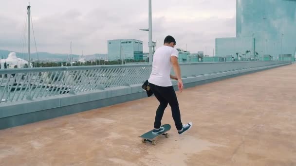 Skateboarder monta un monopatín en la moderna terraza de la ciudad . — Vídeo de stock