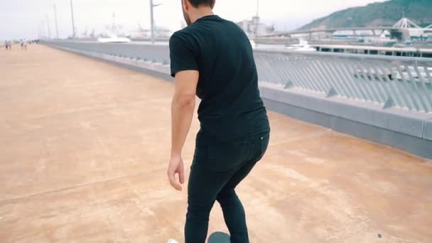 Skateboarder monta un monopatín en la moderna terraza de la ciudad . — Vídeo de stock