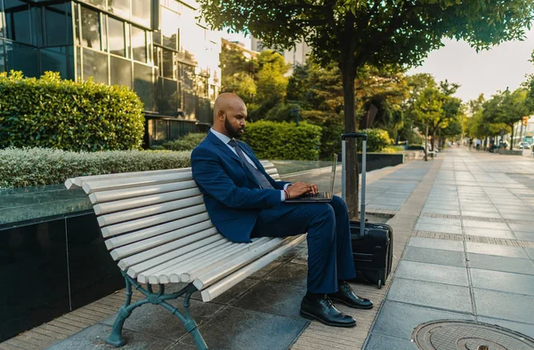 オフィスの近くに青いスーツを着てノートパソコンを持つインドのビジネスマン — ストック写真