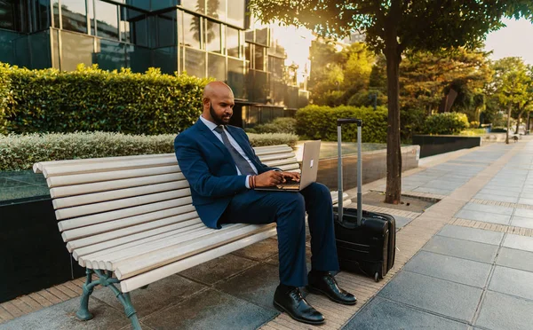 Hombre de negocios indio sosteniendo portátil portátil con traje azul cerca de la oficina —  Fotos de Stock