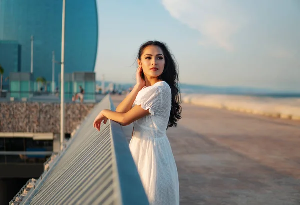Bella ragazza in abito bianco a piedi lungo il lungomare — Foto Stock