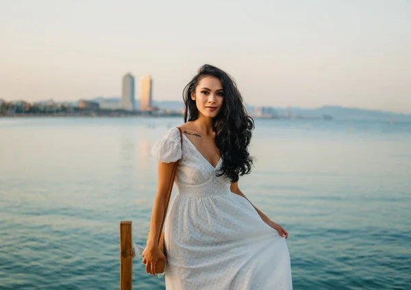 Krásná dívka v bílých šatech podél mořské promenády. — Stock fotografie
