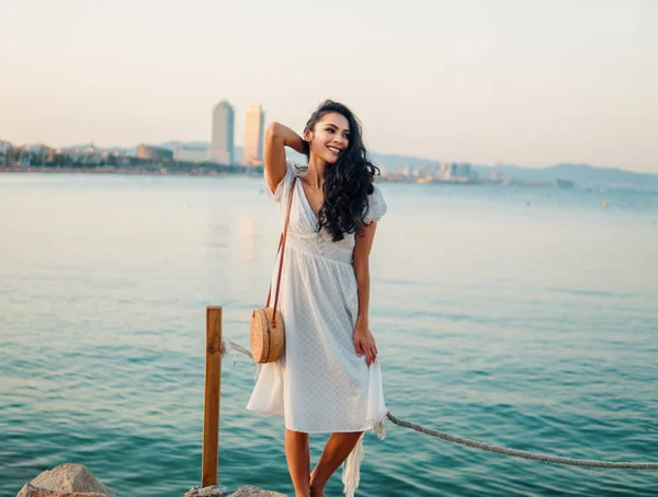 Όμορφο κορίτσι με το λευκό φόρεμα που περπατάει κατά μήκος του θαλάσσιου περιπάτου — Φωτογραφία Αρχείου
