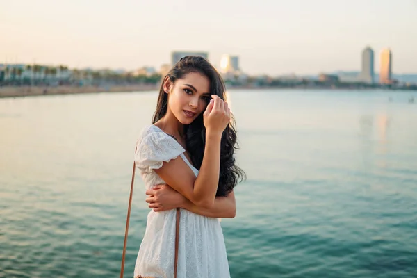 바다 산책로를 따라 흰색 드레스에 아름다운 소녀. — 스톡 사진