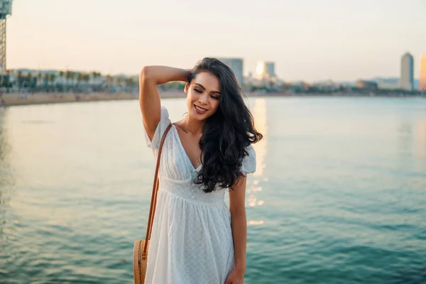 Schönes Mädchen im weißen Kleid an der Strandpromenade. — Stockfoto