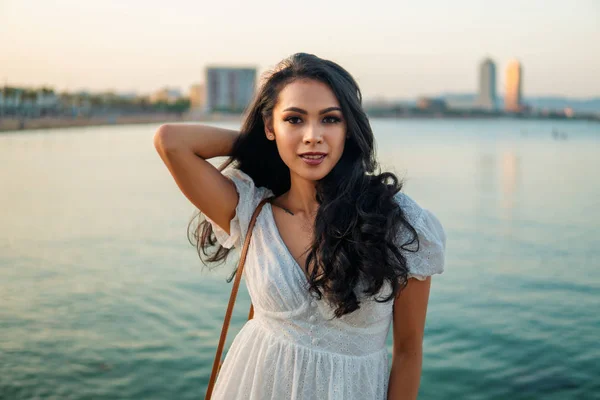 Menina bonita no vestido branco ao longo do passeio marítimo . — Fotografia de Stock