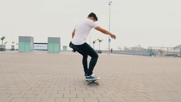 Skateboarder monta un monopatín en la moderna terraza de la ciudad . — Vídeos de Stock