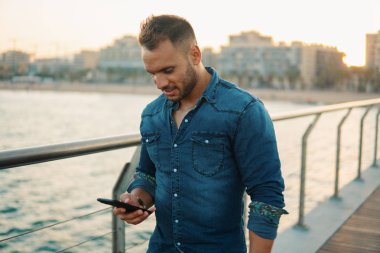 Güzel plaj yakınında köprüde genç yakışıklı bir adam.