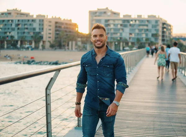 Un joven guapo en el puente cerca de la hermosa playa . —  Fotos de Stock