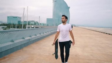 Kaykaycı modern şehir terasında bir kaykay sürmek.