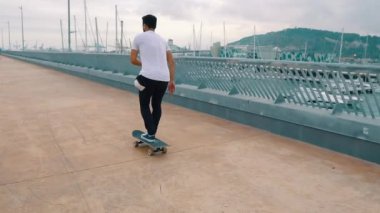 Kaykaycı modern şehir terasında bir kaykay sürmek.