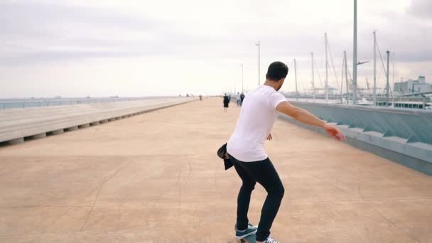 Skateboarder monta un monopatín en la moderna terraza de la ciudad . — Vídeo de stock