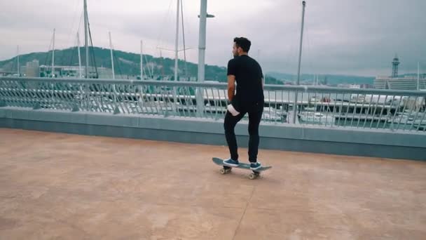 Skateboarder jeździ na deskorolce na nowoczesnym tarasie miejskim. — Wideo stockowe