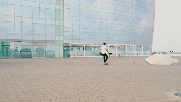 Skateboarder monta un monopatín en la moderna terraza de la ciudad . — Vídeos de Stock