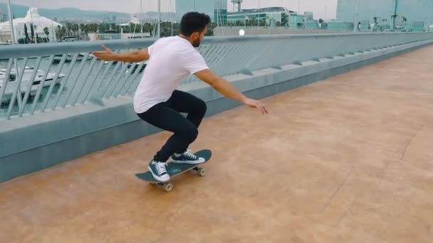 Skateboarder monta un monopatín en la moderna terraza de la ciudad . — Vídeo de stock