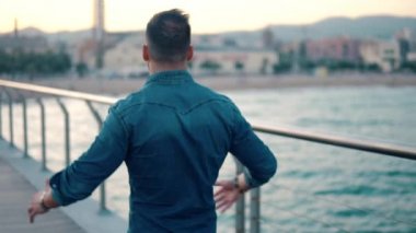 Güzel plaj yakınında köprüde genç yakışıklı bir adam.