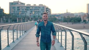 Güzel plaj yakınında köprüde genç yakışıklı bir adam.