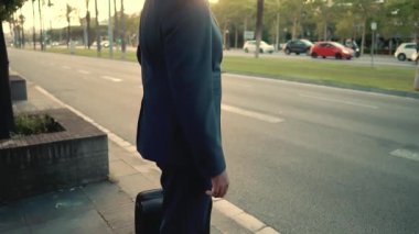 Seyahat çantası veya bavuluyla ayakta mavi takım elbise giyen Hintli işadamı