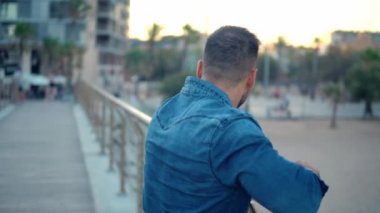 Güzel plaj yakınında köprüde genç yakışıklı bir adam.