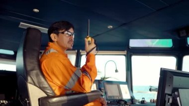 Filipinli güverte subayı gemi ya da gemi köprüsünde. GMDSS VHF radyosunda konuşuyor.