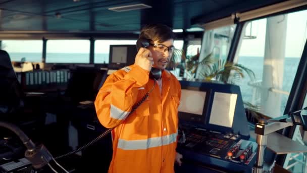 Oficial de cubierta filipino en puente de buque o barco. Él está hablando en la radio VHF GMDSS — Vídeos de Stock