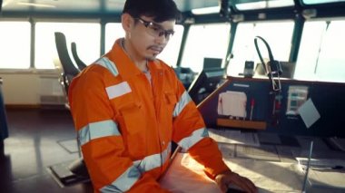 Filipinli güverte subayı gemi ya da gemi köprüsünde. Denizde dizüstü bilgisayar ve elektronik evrak kullanıyor.
