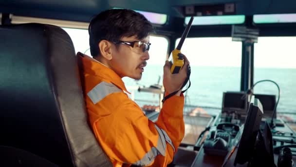 船や船の橋の上にフィリピンのデッキ役員。彼はGMDSS VHFラジオで話している — ストック動画