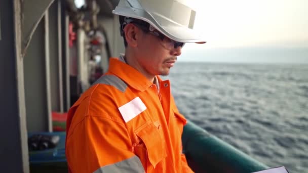 Officier de pont philippin sur le pont du navire offshore ou le navire remplit la liste de contrôle. Papeterie en mer — Video