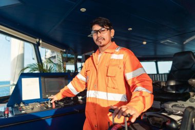 Filipinli güverte subayı gemi ya da gemi köprüsünde. GMDSS VHF radyosunda konuşuyor.