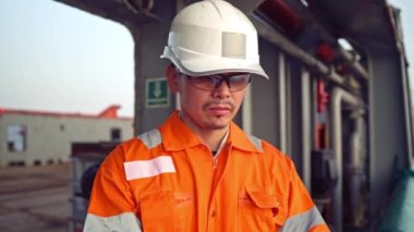 Filipinli güverte subayı kıyı gemisinin güvertesinde kontrol listesini dolduruyor. Denizdeki evrak işleri.