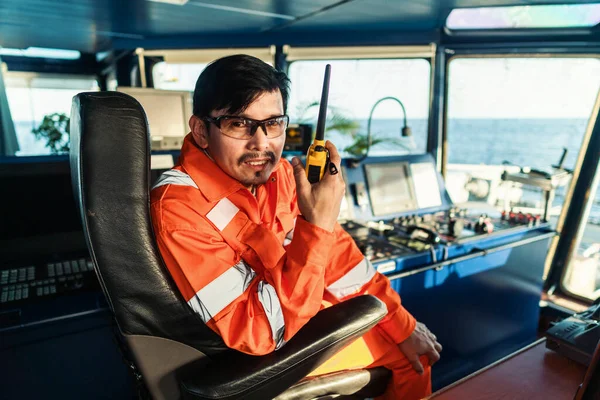 Filipinli güverte subayı gemi ya da gemi köprüsünde. GMDSS VHF radyosunda konuşuyor.