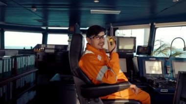 Filipinli güverte subayı gemi ya da gemi köprüsünde. GMDSS VHF radyosunda konuşuyor.