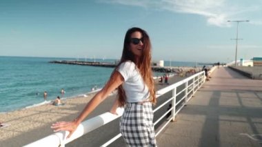 Modern şehirde arka planda gökdelenlerle poz veren seksi şık elbiseli bir kadın.