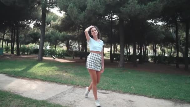 Mujer en sexy vestido elegante posando en el parque verde — Vídeo de stock