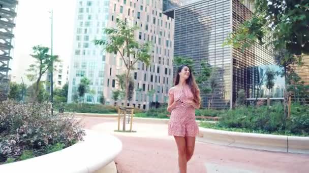 Vrouw in sexy stijlvolle jurk poseren in de moderne stad met wolkenkrabbers op de achtergrond — Stockvideo