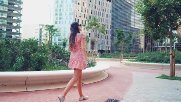 Vrouw in sexy stijlvolle jurk poseren in de moderne stad met wolkenkrabbers op de achtergrond — Stockvideo