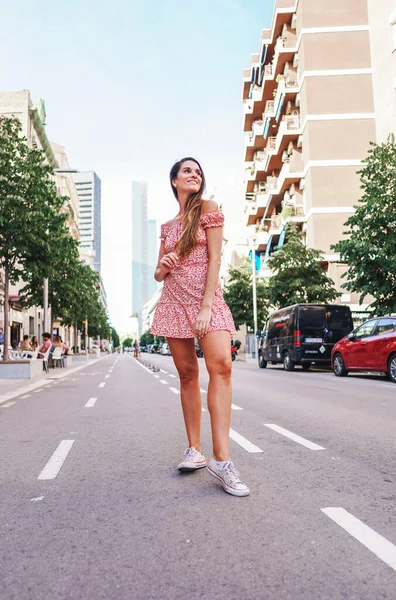 Mulher em vestido sexy elegante posando na cidade com pé na estrada — Fotografia de Stock