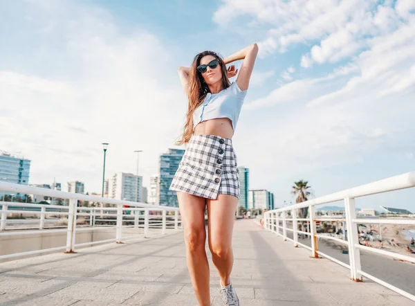 Woman in sexy stylish clothes posing in the modern city with skyscrapers on background — Stock Photo, Image