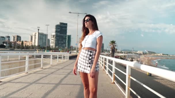 Vrouw in sexy stijlvolle kleding poseren in de moderne stad met wolkenkrabbers op de achtergrond — Stockvideo
