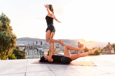 Şehirde akroyoga yapan iki güzel kadın.