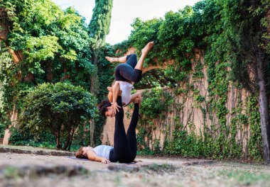 Bahçede veya parkta akroyoga yapan iki güzel kadın.