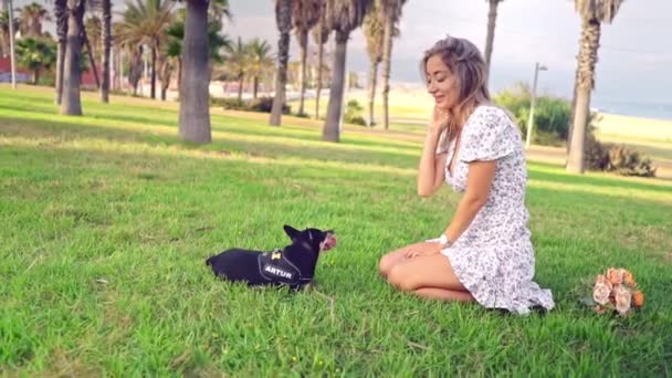 Pequeno cão chamado Artur com proprietário relaxante na grama — Vídeo de Stock