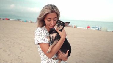 Sahibi Artur adında küçük bir köpek, kumsalda oynayan genç bir kadın.