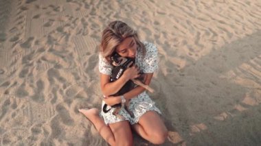 Sahibi Artur adında küçük bir köpek, kumsalda oynayan genç bir kadın.