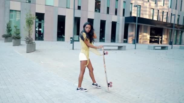 Красива спортивна дівчина їде на дошці в сучасному місті — стокове відео
