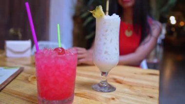 İki çekici genç bayan arkadaş birlikte kokteyl içiyorlar.