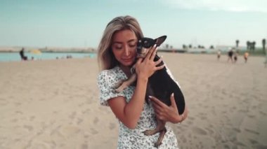 Sahibi Artur adında küçük bir köpek, kumsalda oynayan genç bir kadın.