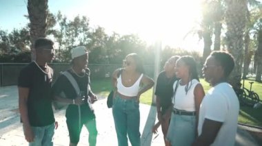 Bir grup modern Afrikalı zenci arkadaş birlikte mutlu bir şekilde yürüyorlar.