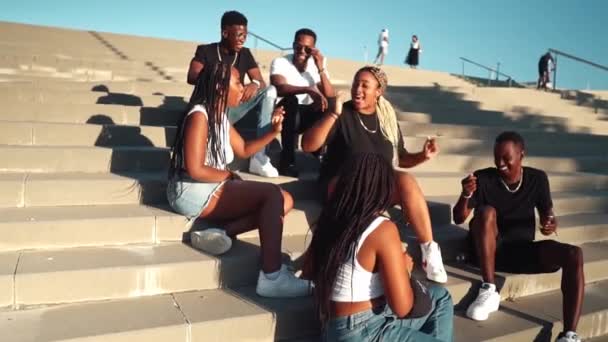 Grupo de jóvenes amigos negros africanos modernos felizmente sentados juntos — Vídeos de Stock