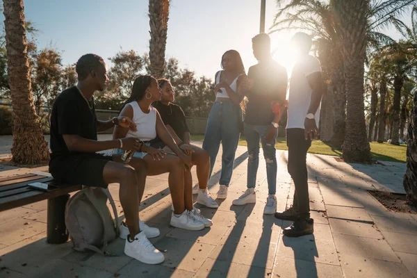 Grupo de jóvenes amigos negros africanos modernos felizmente sentados juntos — Foto de Stock